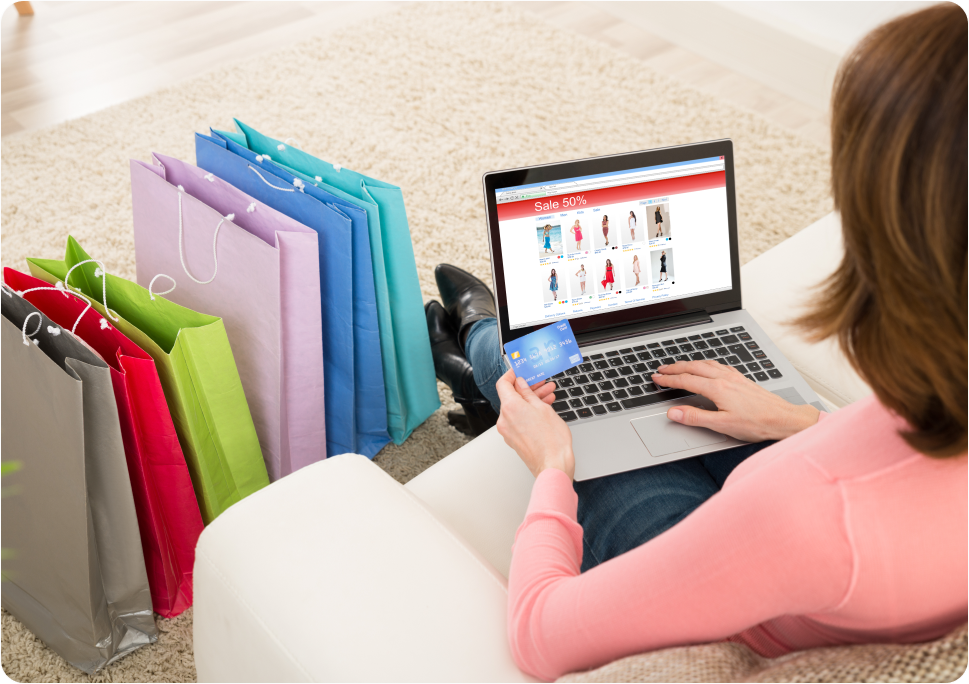 A woman holding a credit card is shopping online